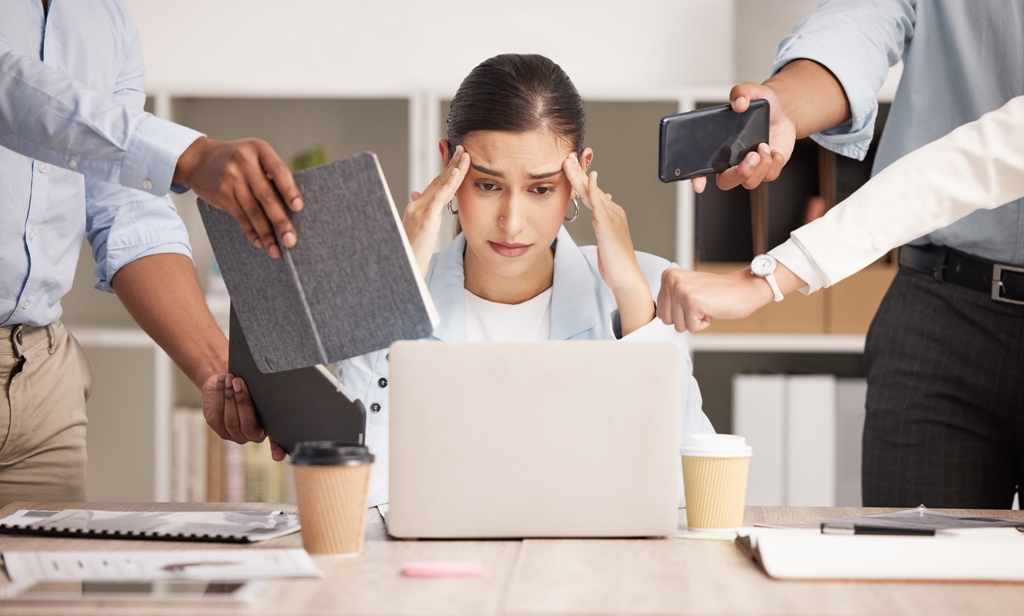 Overwhelmed worker surrounded by tasks, emphasising steps to overcome procrastination