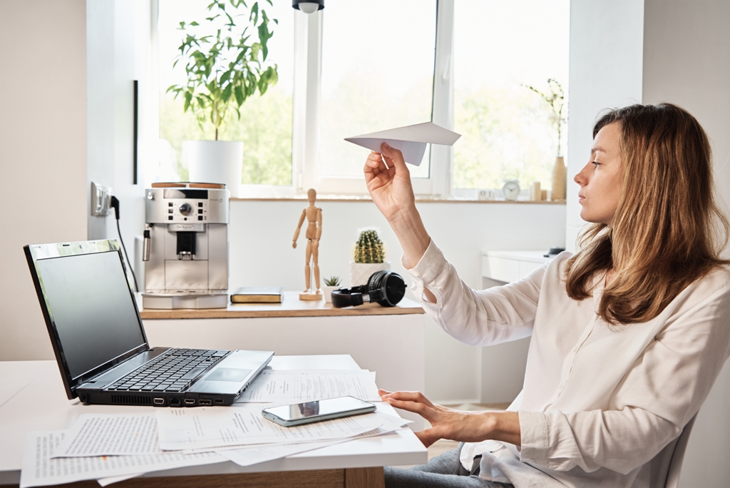 Woman distracted at work, symbolising the causes of procrastination like loss of focus and motivation.