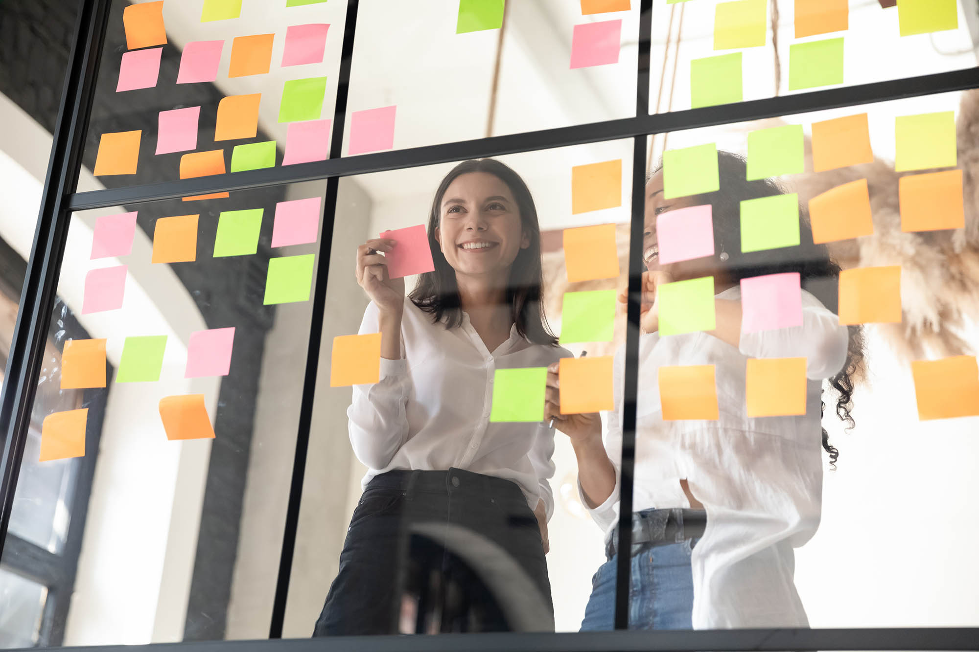 A lady working with sticky notes, symbolising planning and the positive impact of career coaching.