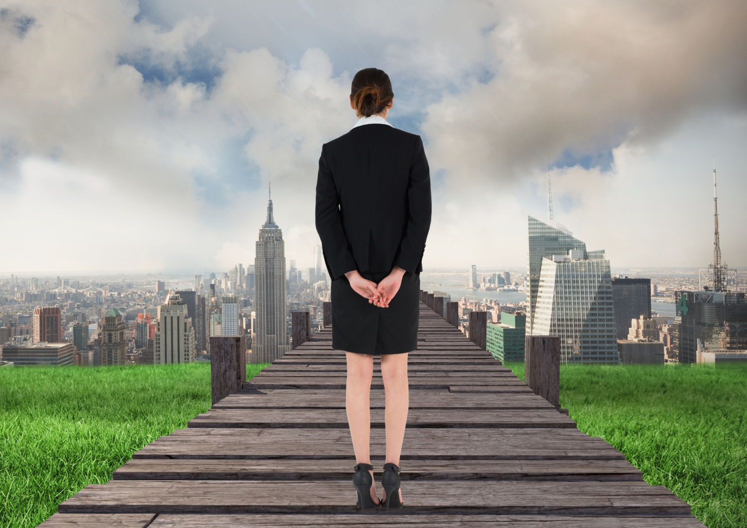 Businesswoman standing on a wooden bridge overlooking a city skyline for career change