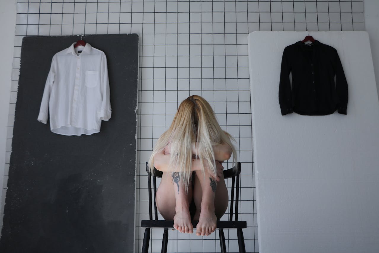 Woman sitting with her head down, showing the emotional weight of anxiety